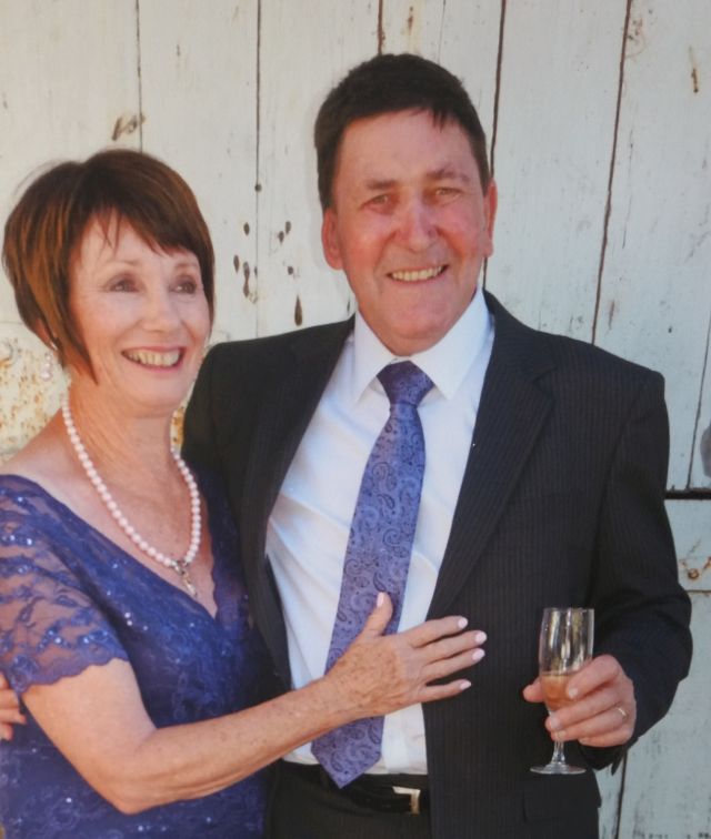New Zealand Christian man telling a joke while his hugging wife laughs