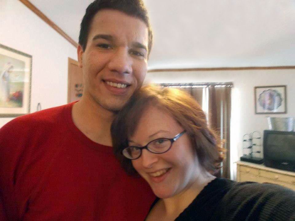 Youthful Christians playfully hugging in living room