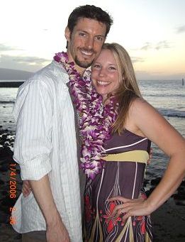 Christian biker engaged in Hawaii stands next to his new fiancee on the beach
