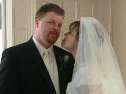 A bride tries to sneak a kiss while the groom is distracted