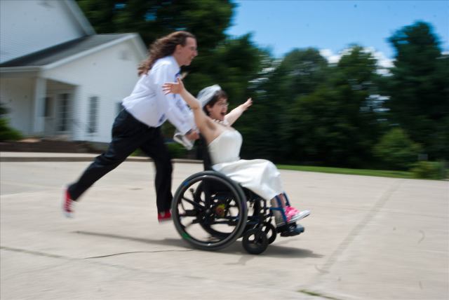 Man pushes woman quickly in wheelchair as she screams in laughter