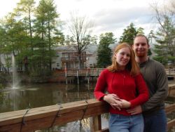 Attractive Christian singles stand close together on a bridge and look very happy