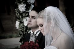 A beautiful couple look pensive as they sit together at their wedding