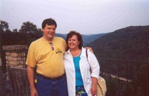 Christian couple hug with hills in the background