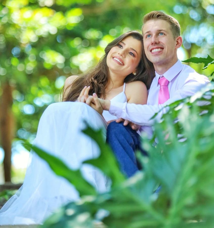 Attractive Christian singles smile together while sitting in the grass
