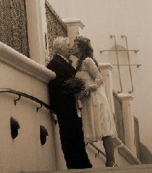 Senior Christian couple kiss on a bridge