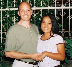 California single man smiles as he holds hands with a beautiful woman from the Philippines