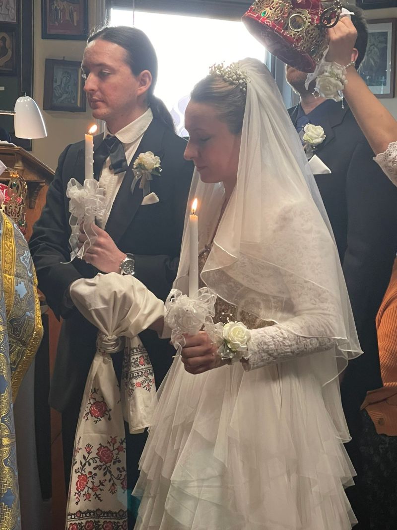 Former single Christians marry in an orthodox ceremony while holding candles and preparing to wear crowns