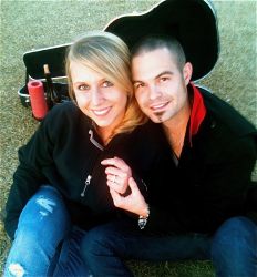 Newly engaged Texas Christian woman shows off her engagement ring while her Texas fiance holds her hand and smiles proudly