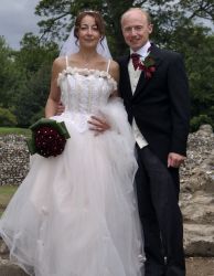 English Christian couple with French connection pose together proudly on their wedding day