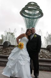 A couple smile excitedly outdoors just after marrying