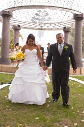 Finally married, a couple walks hand in hand at their outdoor wedding