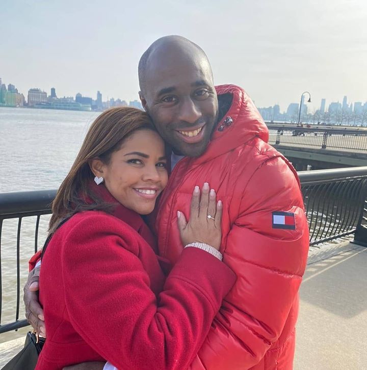 Colombian Christian single smiling and hugging American fiancee outdoors in New Jersey harbor