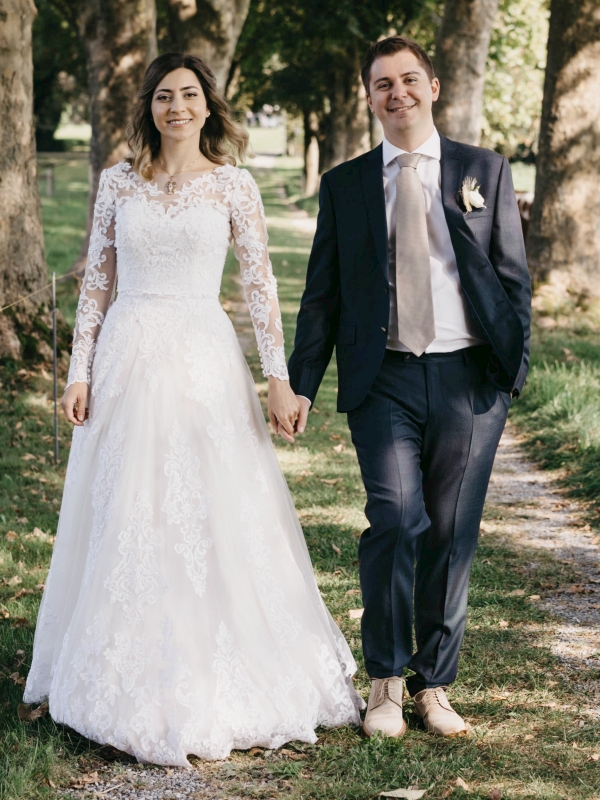 Swiss Christian couple holding hands in tree-lined garden
