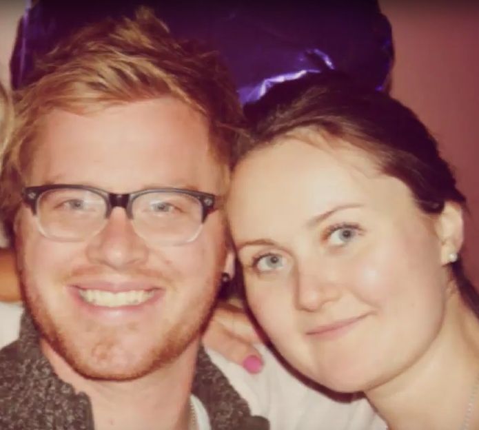 A very happy man smiles as a woman leans in