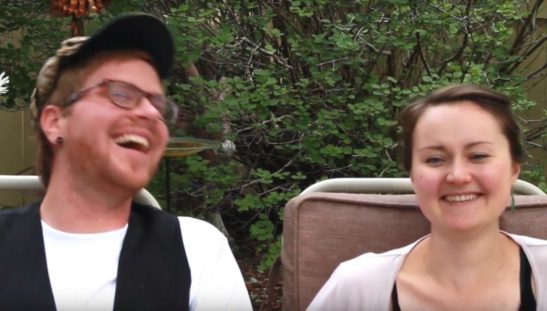 Man leans back and laughs heartily as a woman sitting beside him laughs too