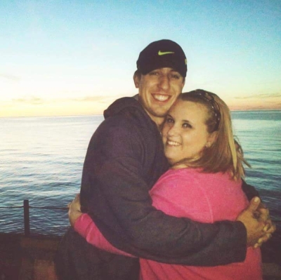 Ohio Christian couple hugging by the ocean at sunset and smiling