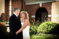 A woman bursts out laughing as a former PA Christian single hugs her on their wedding day