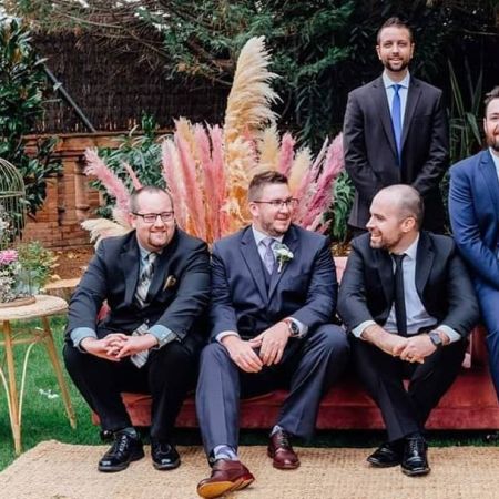 Groomsmen laughing and celebrating with groom while seated