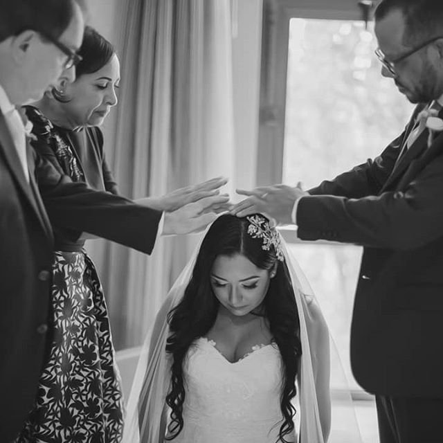 Bride receives prayer and blessings for her marriage from Christians laying their hands on her head