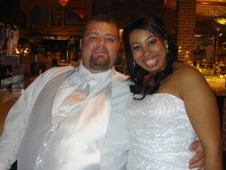 A beautiful woman is hugged at a reception by an overjoyed man