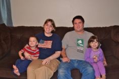 ex-singles from California sit proudly on a brown sofa with their 2 children