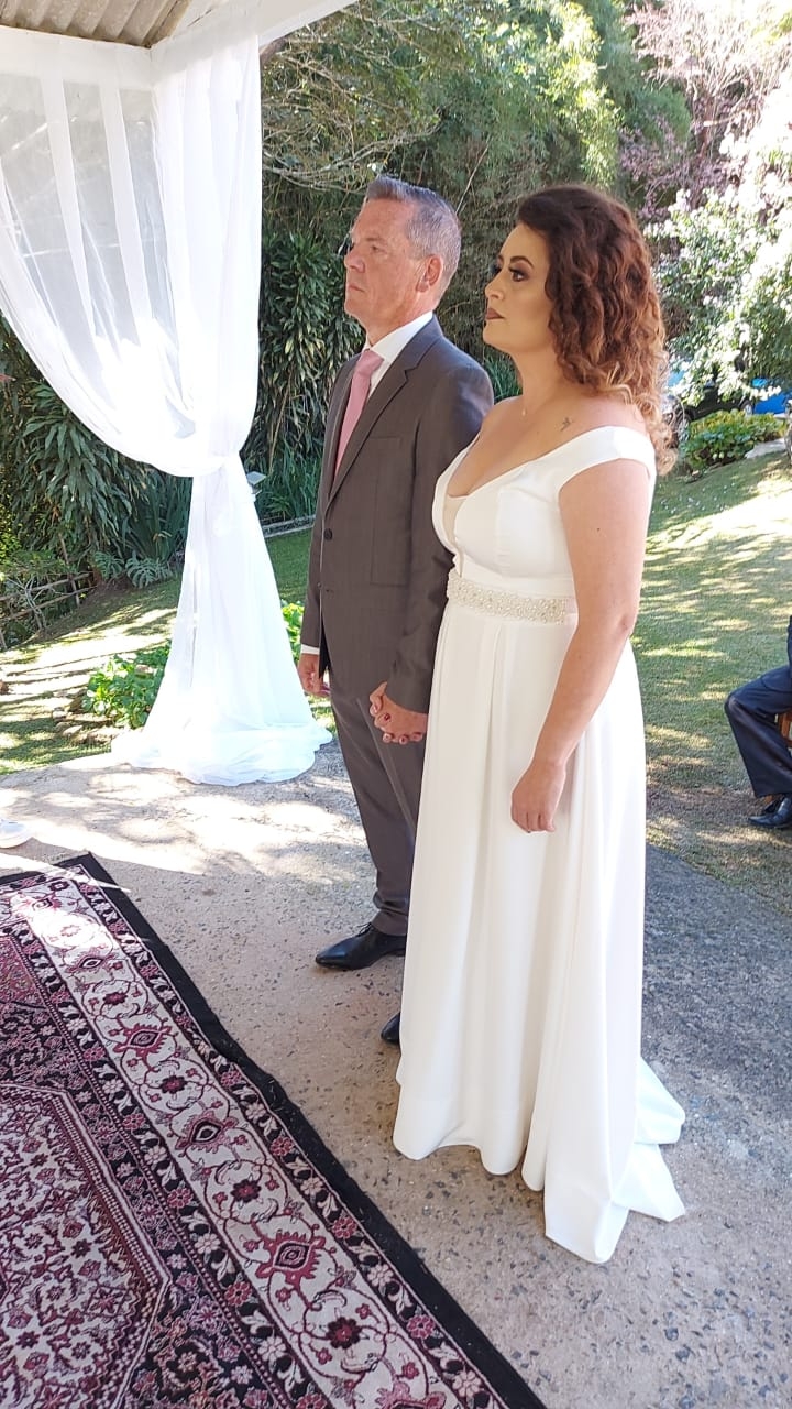 A Christian couple stand hand in hand at their wedding