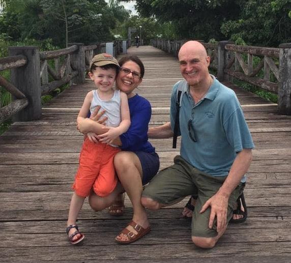 Proud Christian parents on bridge with laughing child