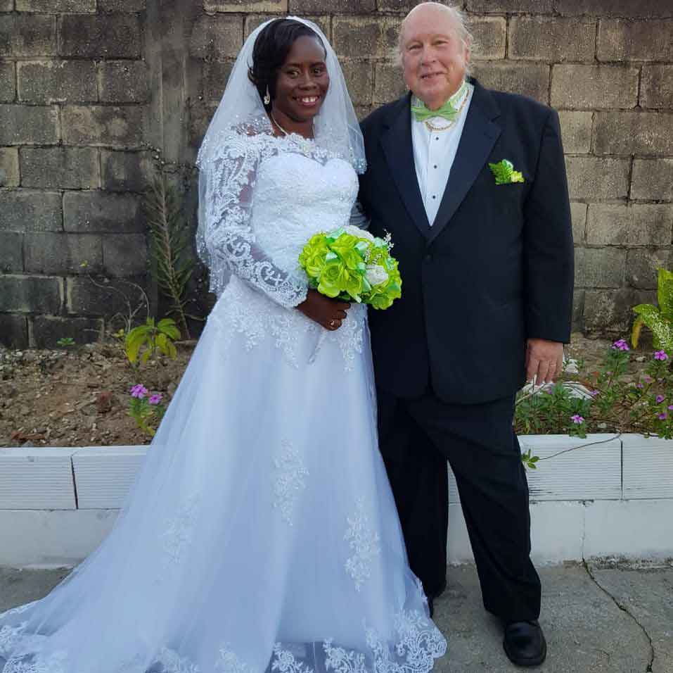 Happily married Christian from Trinidad in white bridal dress stands next to Maryland Christian husband after marrying
