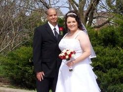 A very happy bride and groom pose outside for their April wedding