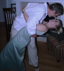 A man dips a woman for a passionate kiss as she laughs
