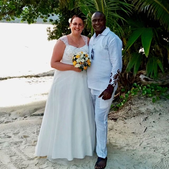 Beach shot for Christian couple newly married. Beautiful bride holding bridal flowers