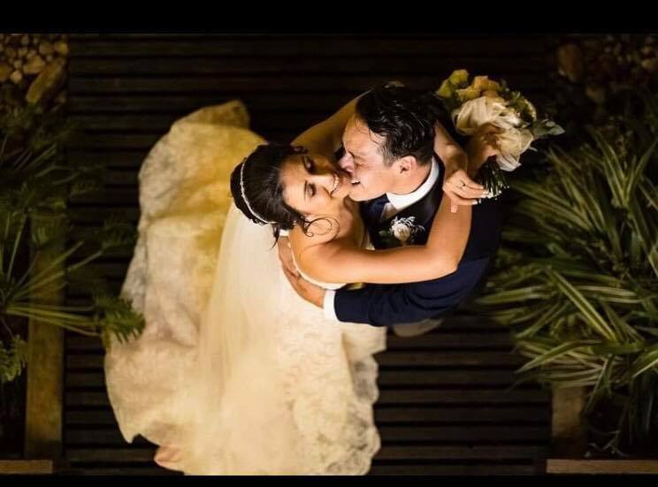 Newly married Christians are seen from above, holding each other and laughing