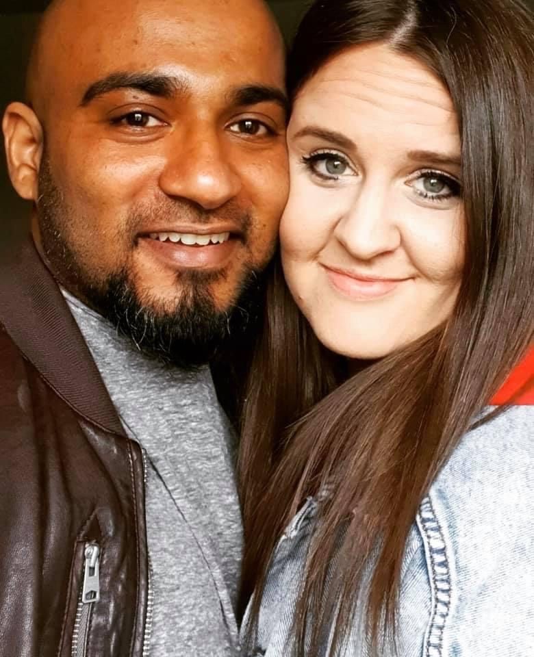 A handsome Indian Christian single man cuddles with a pretty American woman