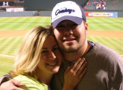 A woman leans in affectionately after meeting a single Christian man at a baseball game