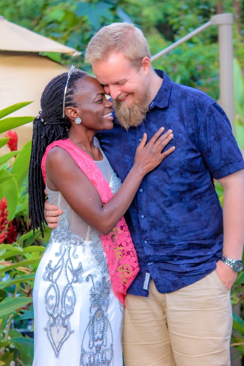 A beautiful Black Christian woman smiles and hugs a handsome White Christian man