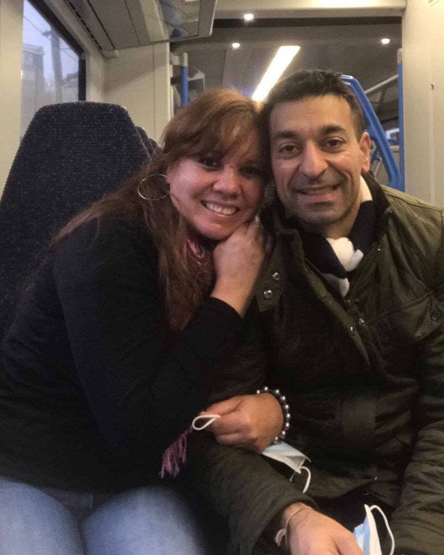 Newly engaged Christians smile and cuddle while on the train