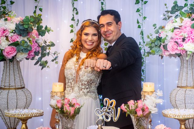 Newly married Christian couple laughing while showing off their wedding rings