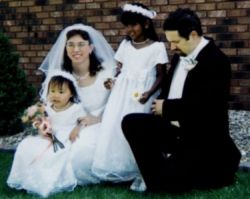 Blended Christian family laugh together at the wedding