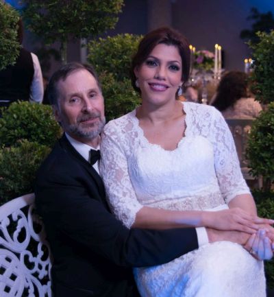 Smiling bride from Dominican sitting with husband who holds her affectionately