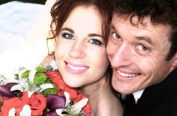 A smiling Christian man sits behind a beautiful woman holding flowers